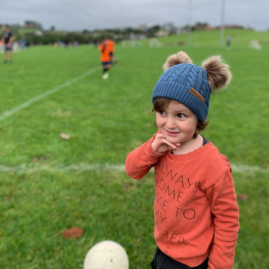 Kid wearing a double pompom beanie in blue - Stick Hunters