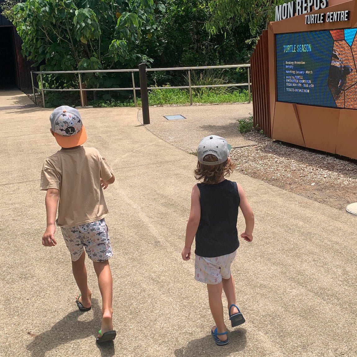 Boy and toddler sunning at a turtle rescue centre wearing trucker hat with sea animals print - Stick Hunters